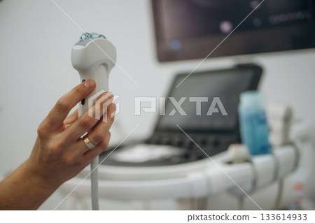 Ready for the work. Doctor is with ultrasound equipment is in the clinic in the room 133614933