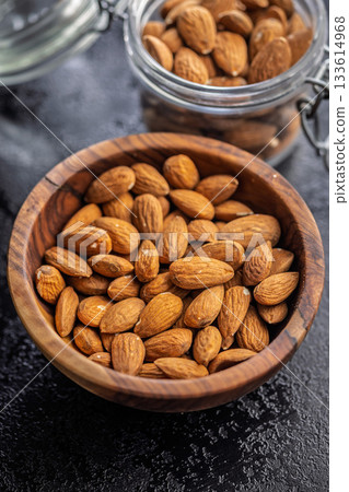 Almond kernel nuts in bowl on black table. 133614968