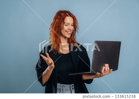 Holding laptop. Woman is in the studio against background Holding laptop. Woman is in the studio against background 133615238