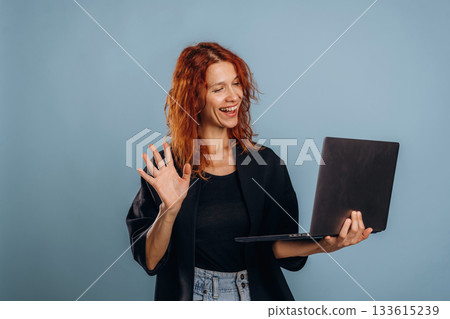 Holding laptop. Woman is in the studio against background Holding laptop. Woman is in the studio against background 133615239