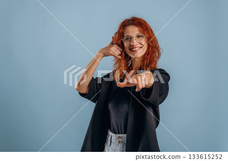 Calling you. Hands gestures. Woman is in the studio against background Calling you. Hands gestures. Woman is in the studio against background 133615252