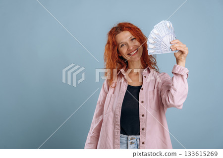 Bunch of currency, holding money. Woman is in the studio against background Bunch of currency, holding money. Woman is in the studio against background 133615269