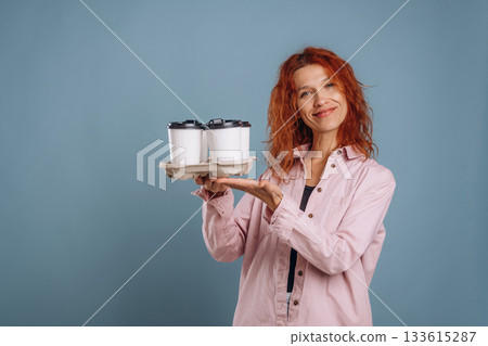 Cups of coffee, hot drink. Woman is in the studio against background 133615287