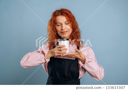 Fresh drink in white paper cup. Woman is in the studio against background 133615307