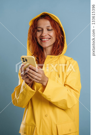 Phone in hands. Woman is in the studio against background Phone in hands. Woman is in the studio against background 133615396