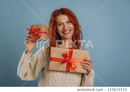 Christmas presents. Woman is in the studio against background 133615510