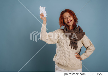 In scarf and with napkins, feeling sick. Woman is in the studio against background 133615516