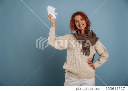 In scarf and with napkins, feeling sick. Woman is in the studio against background 133615517