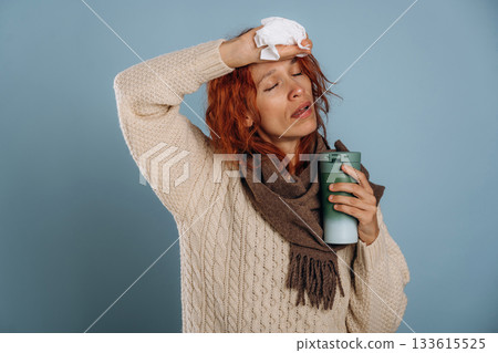 Sick, feeling bad. With thermos and napkin. Woman is in the studio against background Sick, feeling bad. With thermos and napkin. Woman is in the studio against background 133615525