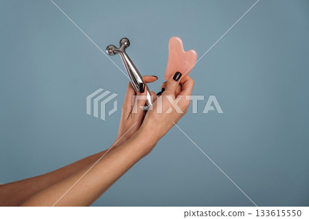 Woman is holding the roller massager against background Woman is holding the roller massager against background 133615550