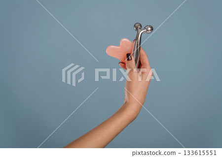 Woman is holding the roller massager against background Woman is holding the roller massager against background 133615551