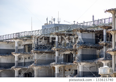 A view of a concrete structure undergoing demolition and remaining pillars 133615740
