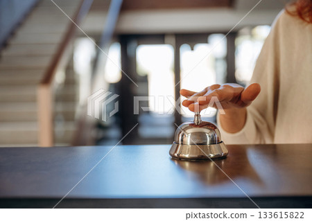 Rings the bell. Woman is at reception of the modern hotel Rings the bell. Woman is at reception of the modern hotel 133615822