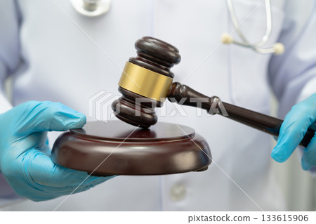 Doctor holding judge gavel, forensic medicine, medical law and crime justice. 133615906