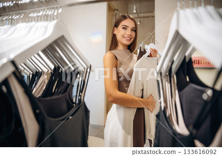 Woman chooses clothes in retail store 133616092