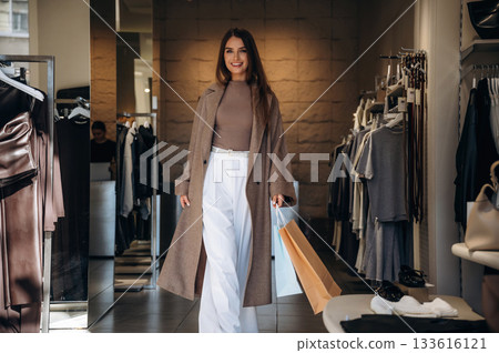 Happy facial expression. Woman chooses clothes in retail store Happy facial expression. Woman chooses clothes in retail store 133616121