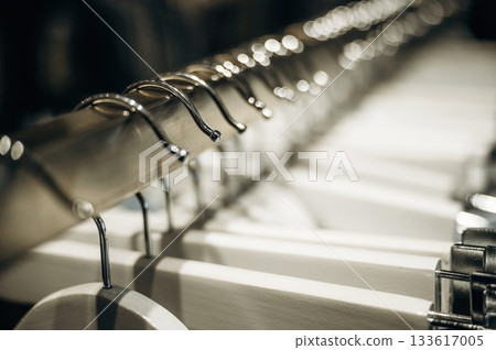 Close up view of hangers under artificial lighting. Conception of clothes and wear 133617005