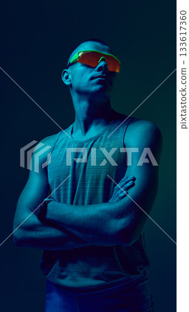Athlete looking upward with neon sports visor and teal lighting 133617360