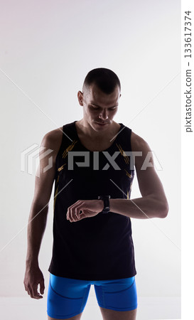 Athlete checking smartwatch after workout. 133617374