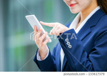 Business woman handling a smartphone hand 133617379
