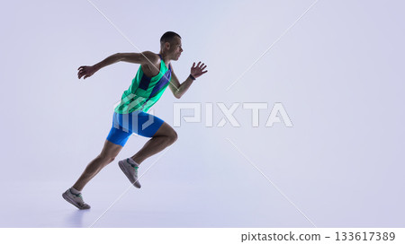 Runner pushing into powerful sprint position 133617389