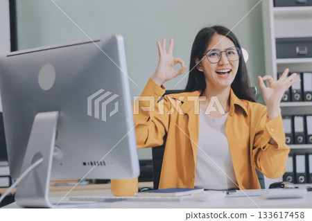 Business woman using calculator for do math finance on wooden desk in office and business working background, tax, accounting, statistics and analytic research concept. 133617458