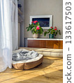 Soft pet bed in a sunny home corner with wooden floor, indoor plants, and natural light. 133617503
