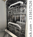 Open empty dishwasher with clean metal racks in a modern kitchen setting. Home Cleaning Routine 133617526