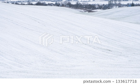 Snow-covered field with gentle winter lines and soft textured surface Snow-covered field with gentle winter lines and soft textured surface 133617718