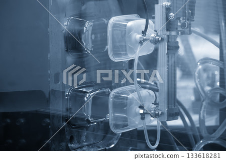 Close up scene material handling process the food container by robotic system from injection machine. 133618281