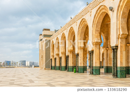 Wide square and exterior arches with carved stone columns and traditional tilework at the Hassan II Mosque, Casablanca, Morocco 133618290