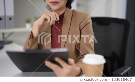 Older Asian business woman senior executive leader analyzing financial reports planning corporate strategy developing future business growth at modern office desk professional work environment Older Asian business woman senior executive leader analyzing financial reports planning corporate strategy developing future business growth at modern office desk professional work environment 133618467