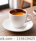 White coffee cup filled with dark coffee on a wooden table white cup brown interior 133619425