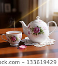 White porcelain teapot and teacup with pink roses on wooden table image 133619429