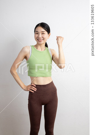 A smiling middle-aged woman wearing yoga wear and doing a fist pump A smiling middle-aged woman wearing yoga wear and doing a fist pump 133619605