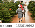Children in a red caps choose a Christmas tree in a shop 133619692
