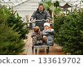 Father and children choose a Christmas tree at a forestry. 133619702