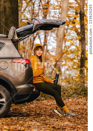 Woman Sitting in Car Trunk in Autumn Forest Woman Sitting in Car Trunk in Autumn Forest 133620265