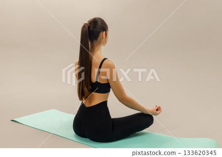 Woman sitting in yoga meditation pose on mat, practicing yoga breathing and relaxation, wellness routine and mindful fitness for calm balance and healthy lifestyle. Woman sitting in yoga meditation pose on mat, practicing yoga breathing and relaxation, wellness routine and mindful fitness for calm balance and healthy lifestyle. 133620345