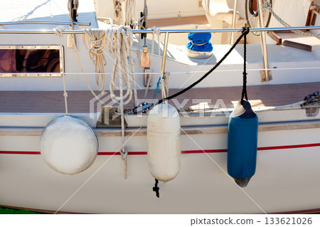 fender buoys on sailboat side with ropes fender buoys on sailboat side with ropes 133621026