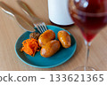 Glass of wine and sausage appetizer / Natural light table scene 133621365