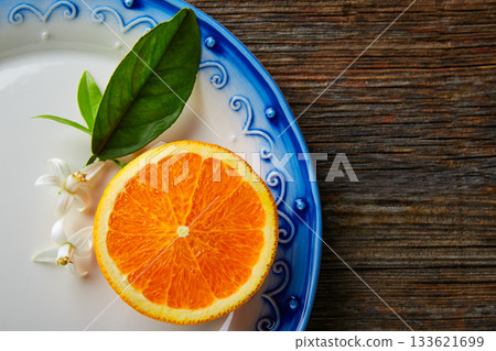 Cut open orange fruit with orange flower Cut open orange fruit with orange flower 133621699