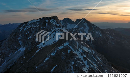Rocky snow mountains at sunset aerial 133621907