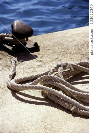 Boat bollard, ropes and knots in mediterranean harbor 133622349