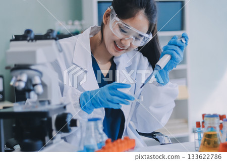 Portrait, science and happy woman on laptop in lab to research chemistry, test or innovation. Microscope, scientist and face of medical doctor in goggles for microbiology, healthcare or pharma study 133622786