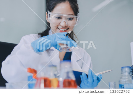 Portrait, science and happy woman on laptop in lab to research chemistry, test or innovation. Microscope, scientist and face of medical doctor in goggles for microbiology, healthcare or pharma study 133622792