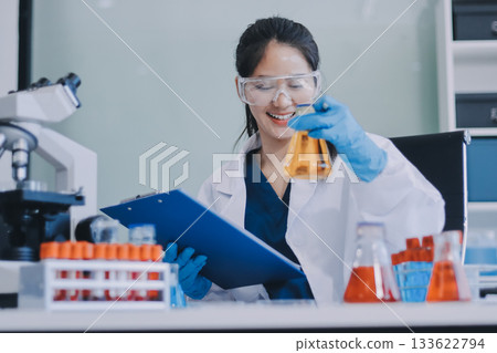 Portrait, science and happy woman on laptop in lab to research chemistry, test or innovation. Microscope, scientist and face of medical doctor in goggles for microbiology, healthcare or pharma study 133622794