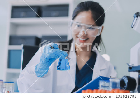 Portrait, science and happy woman on laptop in lab to research chemistry, test or innovation. Microscope, scientist and face of medical doctor in goggles for microbiology, healthcare or pharma study 133622795