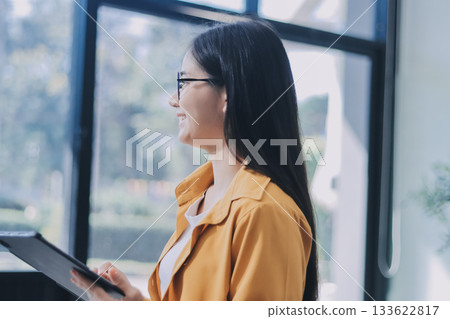 Business woman using calculator for do math finance on wooden desk in office and business working background, tax, accounting, statistics and analytic research concept. 133622817