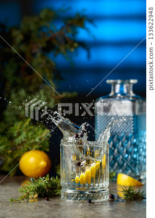 Slice of lemon fall in glass with cocktail, creating beautiful splashes. Slice of lemon fall in glass with cocktail, creating beautiful splashes. 133622948